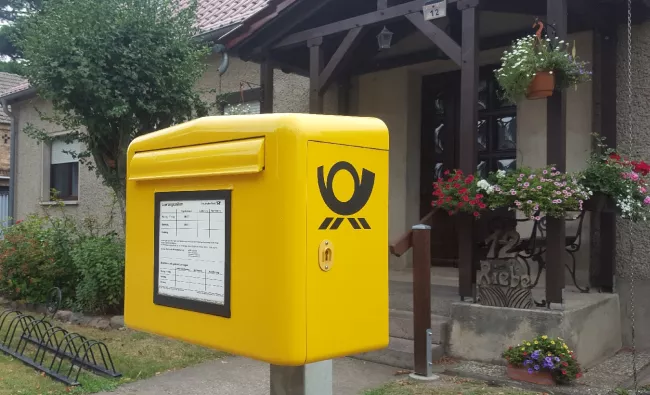 Bild eines gelben Post-Briefkasten
