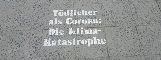 Straßen-Graffito "Tödlicher als Corona: Die Klima-Katastrophe"