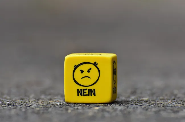 Gelber Würfel mit wütendem Smiley: NEIN