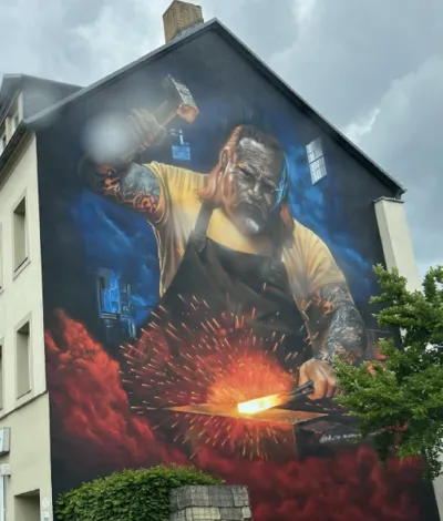 Hauswand mit Graffiti: Schmied, der den Hammer schwingt